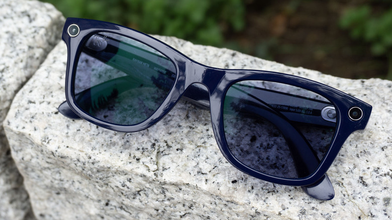 The second-gen Ray-Ban Meta glasses against a white brick.